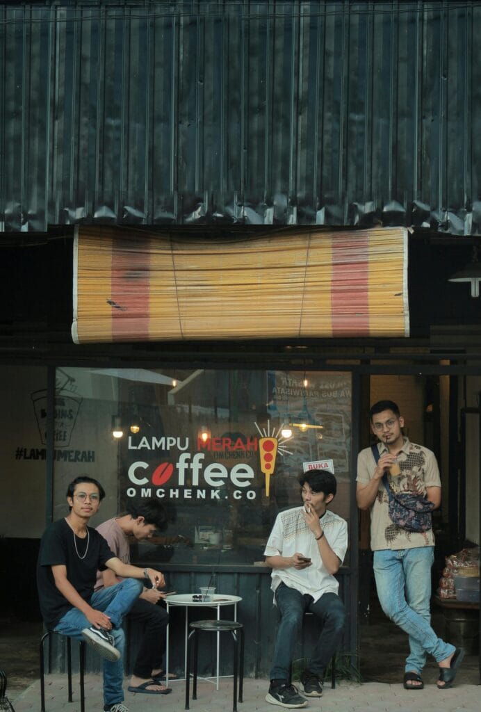 A group of men socializing outside a trendy coffee shop.