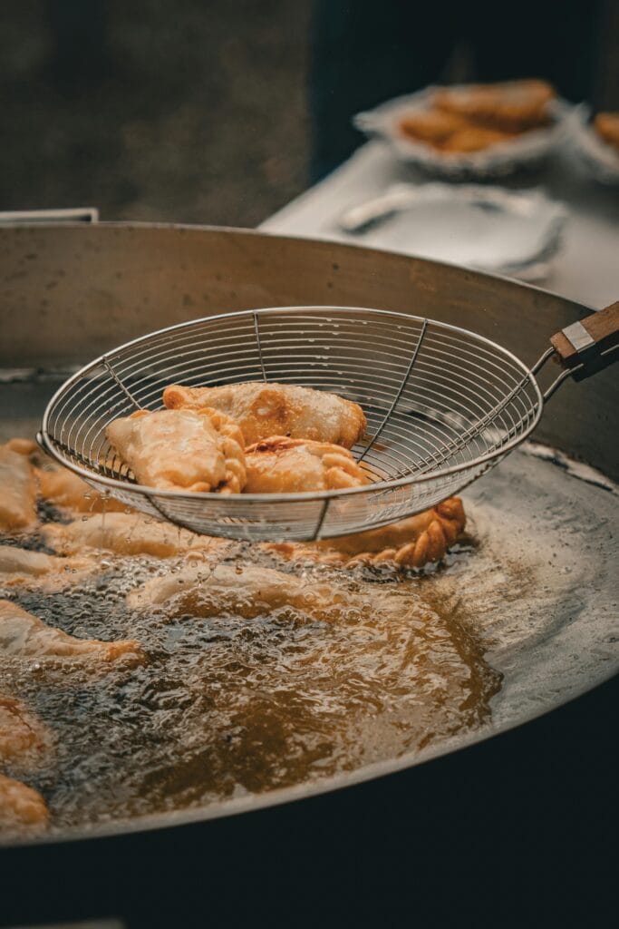 Hot and crispy empanadas being fried to perfection in a pan filled with oil.